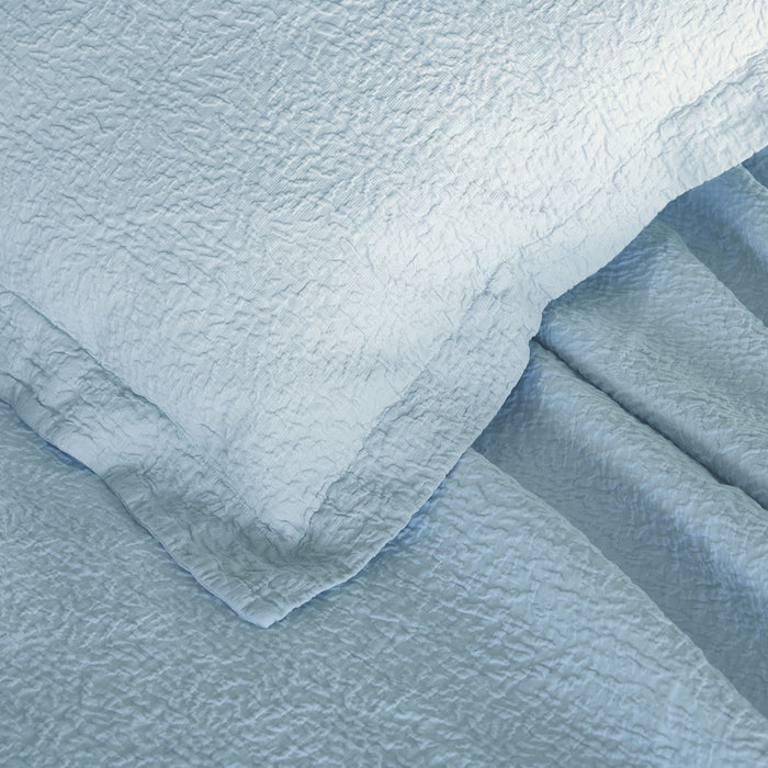 Tamara-Blue decorative pillowcase on top of a tamara blue bed spread