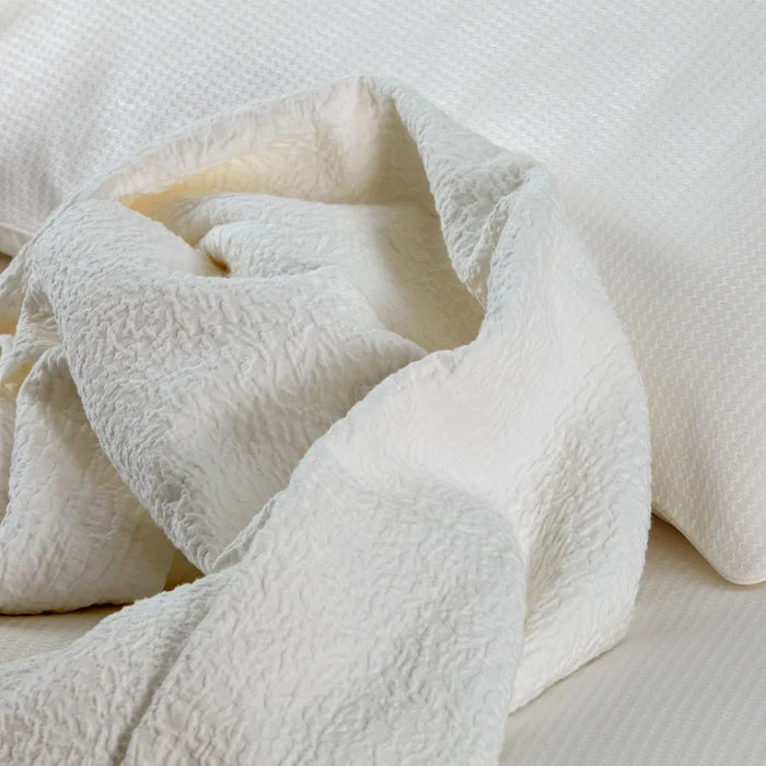 Close-up of amalia tamara_cream_bedspread on a bed
