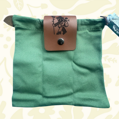 Forager Provisions LTD green up-cycled cotton canvas pouch with a branded vegan leather flap in a woodland setting