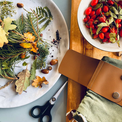 Forager Provisions LTD Forager Set featuring a green canvas pouch, scissors, and a plate of woodland finds and rosehips