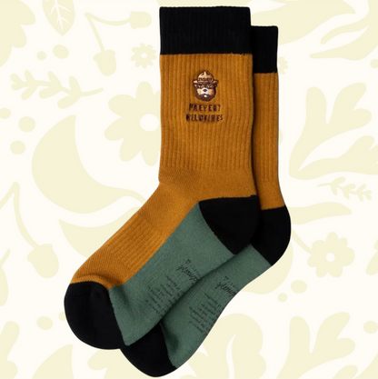 Forager Provisions LTD Smokey Bear message socks in mustard yellow and green with black cuffs and wildfire warning text
