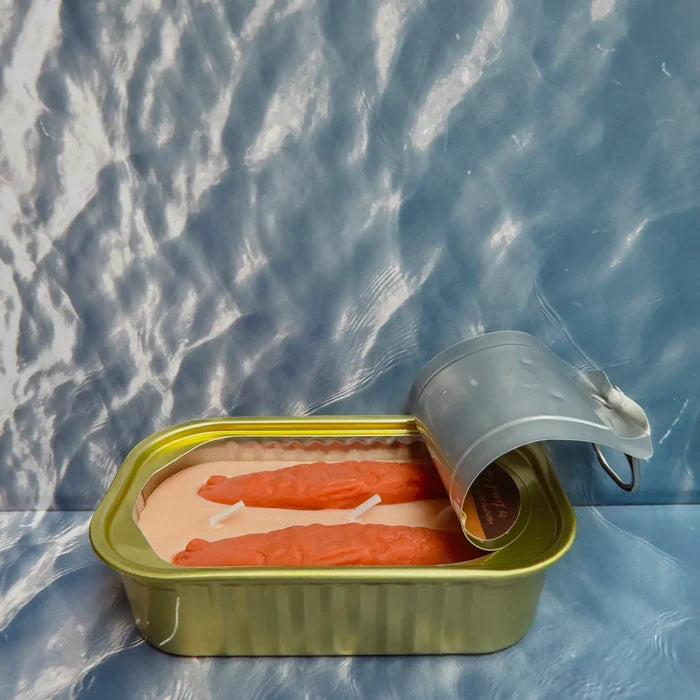 Two Oakmoss & Amber candles in a sardine-style tin by Tinned Candle on a blue, water-inspired background for home fragrance.