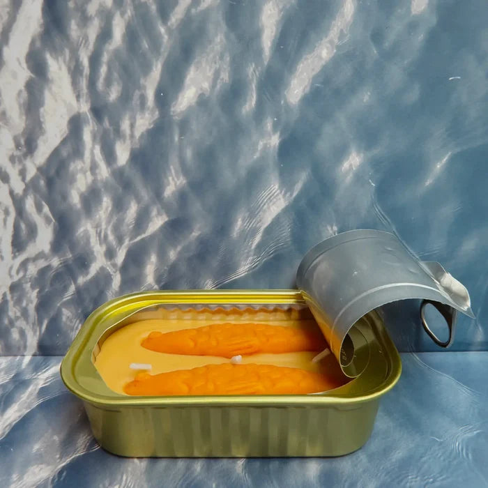 Sandalwood scented Original Tinned Fish Candle by Tinned Candle in open sardine tin, displayed on blue patterned background.