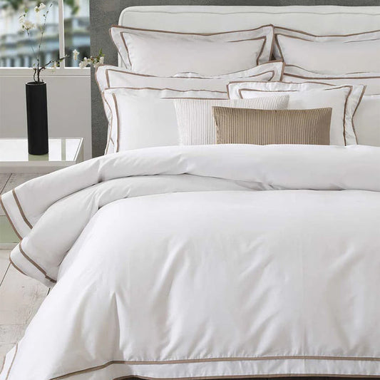 Neatly made bed with Thenney White Duvet Cover Set and decorative pillows in a bedroom setting.