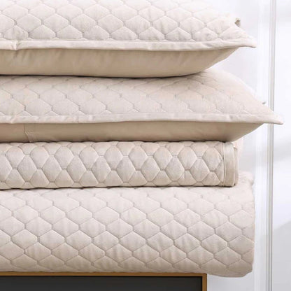 Stack of Turner latte pillows cushions on Turner Bedrunner Latte, on a wooden frame against a white background