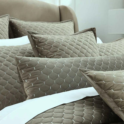 Turner Oak Pillows and Cushions on a bed with white sheets.