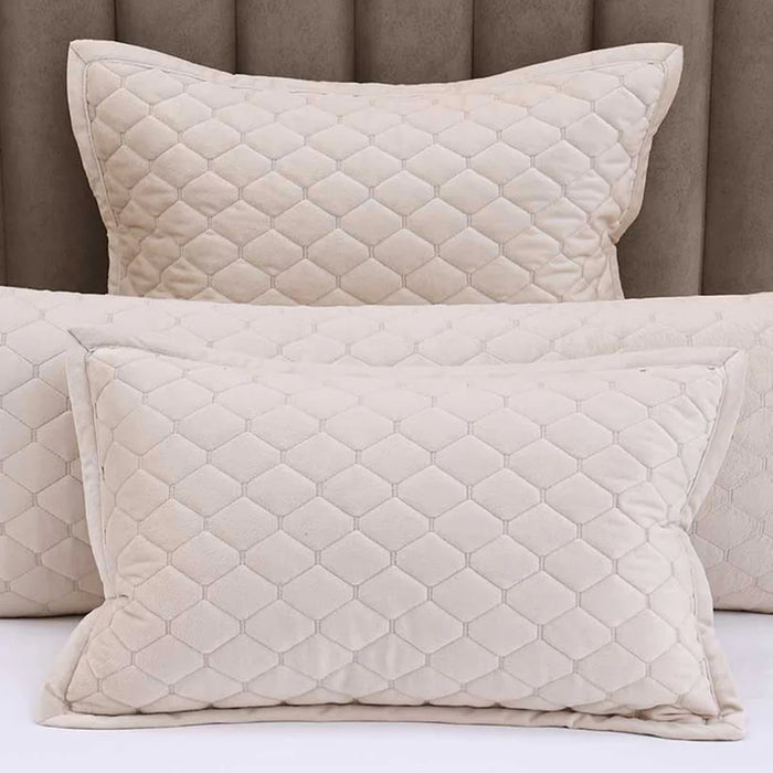 Turner Latte Pillows and Cushions on a bed with a brown headboard.