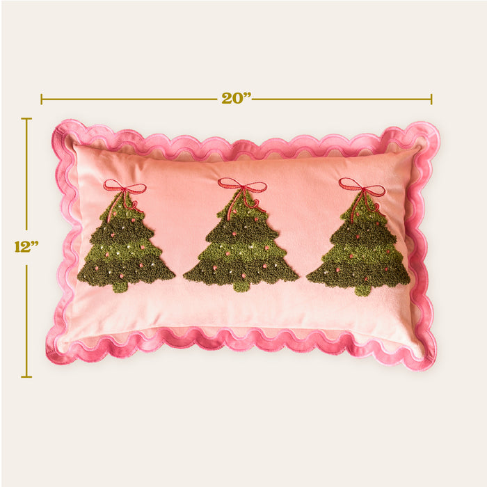 The Darling Effect's Twinkling Trees Scalloped Rectangle Throw Pillow adds a cozy, festive touch with pink fabric, embroidered green Christmas trees, red bows, and pink ornaments. Measures 12" x 20".