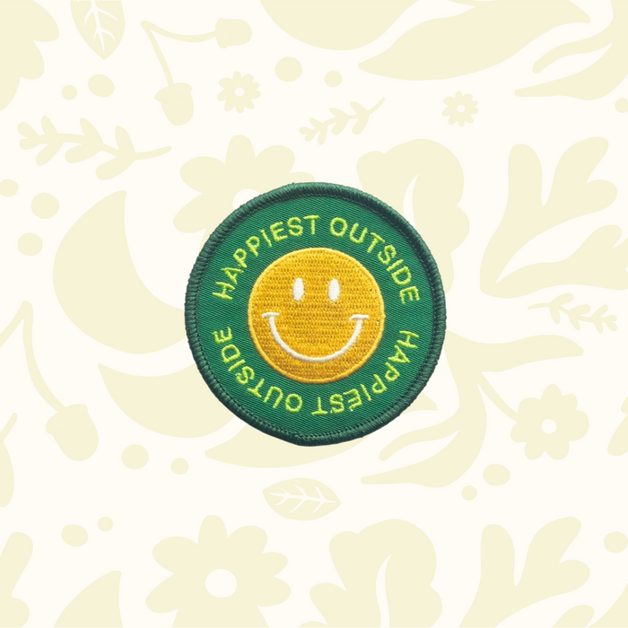 Forager Provisions LTD round embroidered iron-on patch with a yellow smiley face on a green background