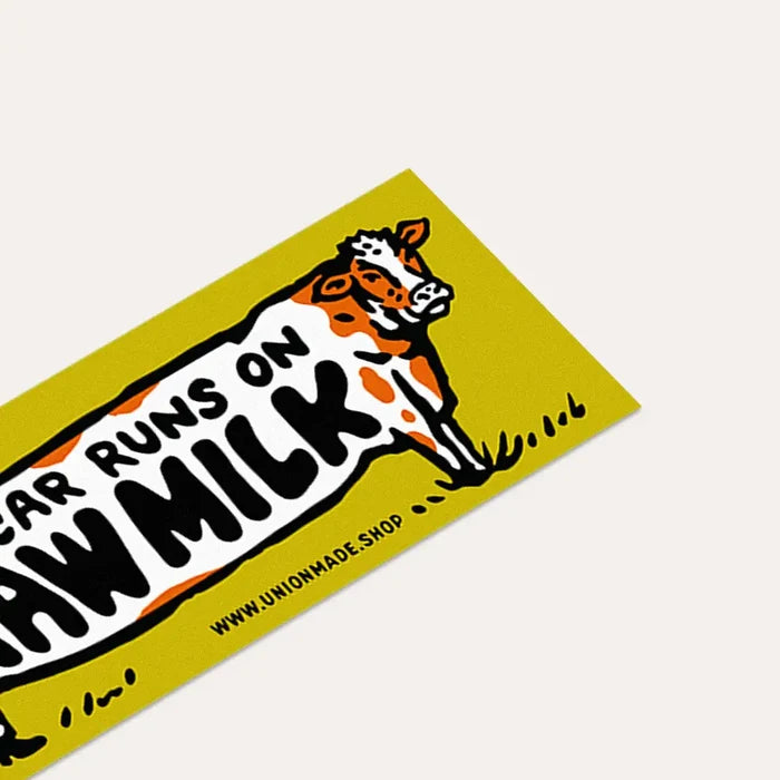 Union Made yellow vinyl bumper sticker reads “This Car Runs On Raw Milk” with a cartoon cow, perfect for dairy lovers.