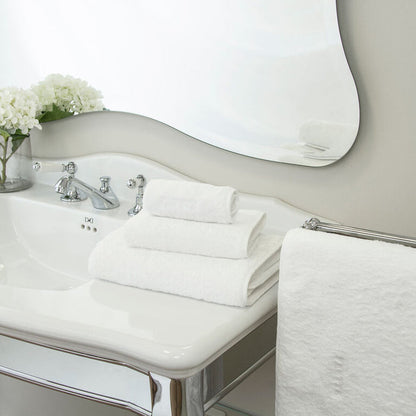 a white Unito Bath towel stacked on unito towles in a modern bathroom setting