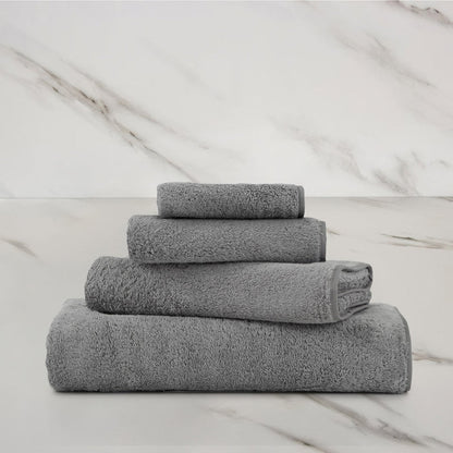 Unito Slate Grey Bath Towel on a marble surface