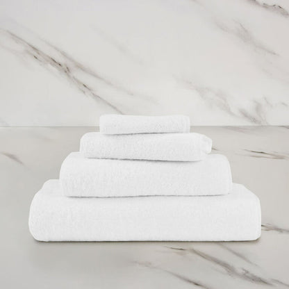 a white unito hand towel stacked on unito towels on a marbeled surface and background