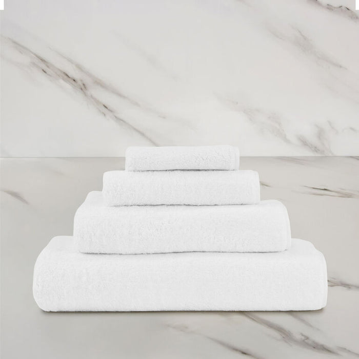 a white unito hand towel stacked on unito towels on a marbeled surface and background