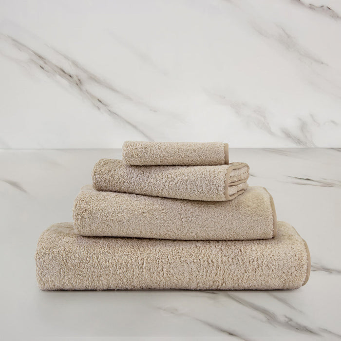 Unito Savage Beige Guest Towel on a marble surface