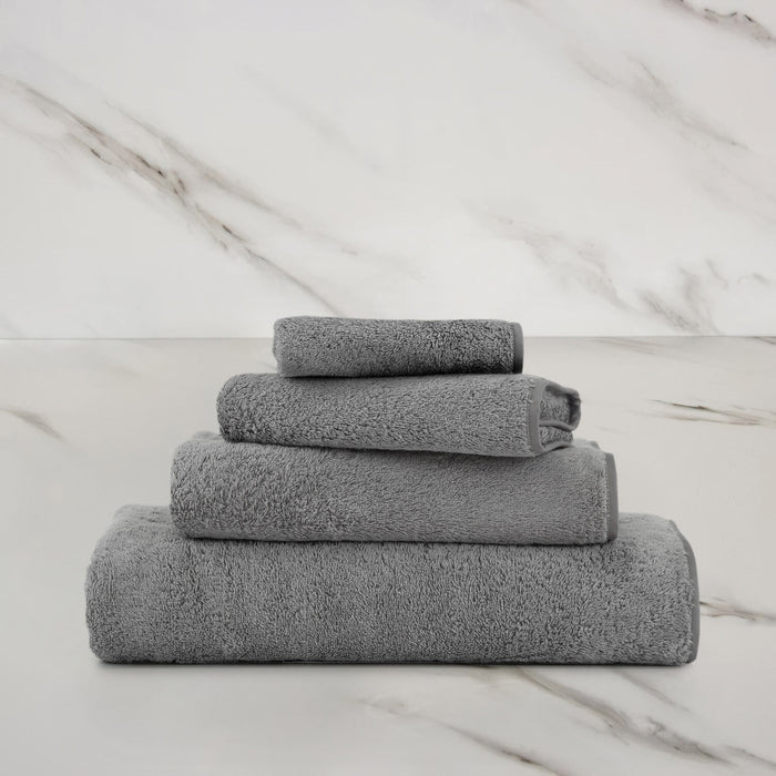 Unito Slate Grey Guest Towel on a marble surface