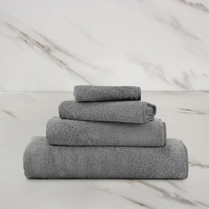 Unito Slate Grey Guest Towel on a marble surface