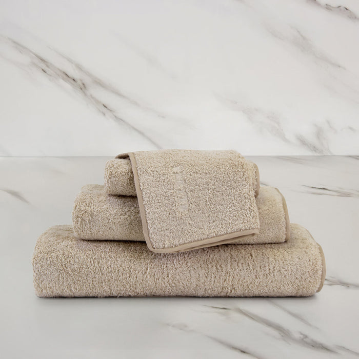 Unito Savage Beige Wash Cloth on a marble surface