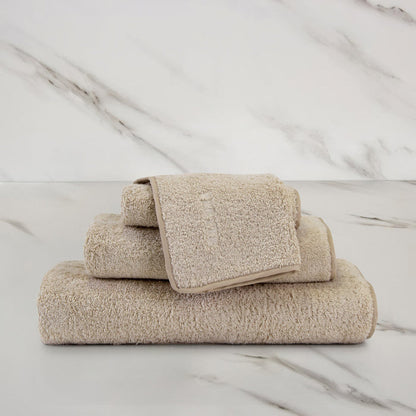 Unito Savage Beige Wash Cloth on a marble surface