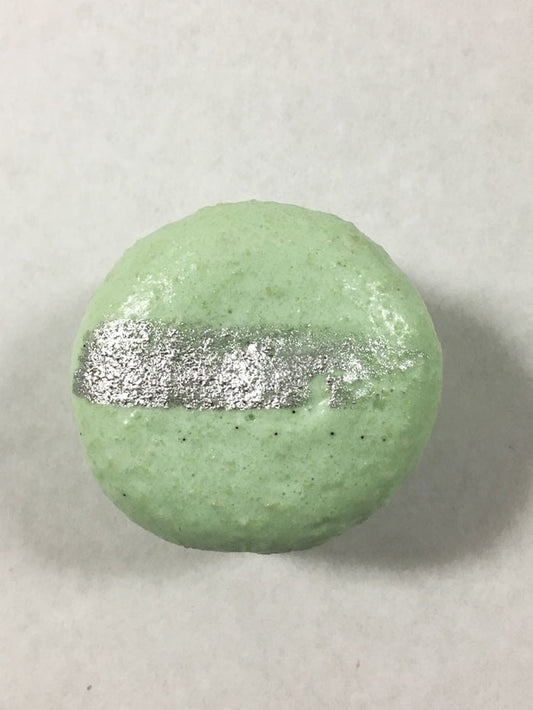 A green-colored macaron with a silver streak on its surface.