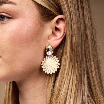 Close-up of a woman's ear wearing The Darling Effect's White Radiant Gem Earrings—lightweight boho teardrop gems with starburst-shaped dangles and beaded accents—perfect for everyday style.