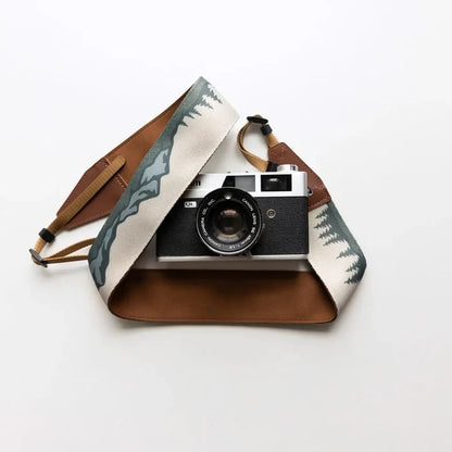 Vintage film camera with Wildtree Landscape Camera Strap (trees, mountains) on clean white background—perfect for photography lovers.