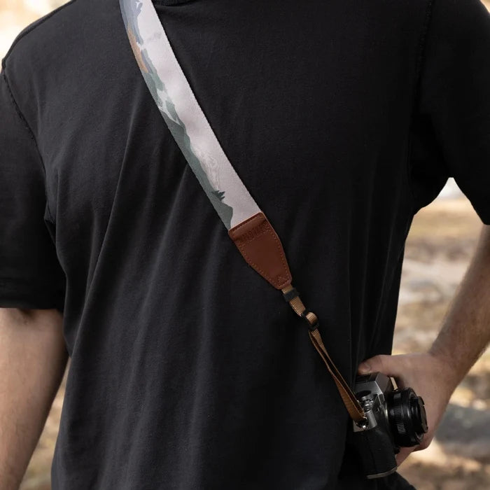 Person in black shirt wearing Wildtree Parks In Colour Camera Strap by Wildtree, stylish camera accessory across their back.
