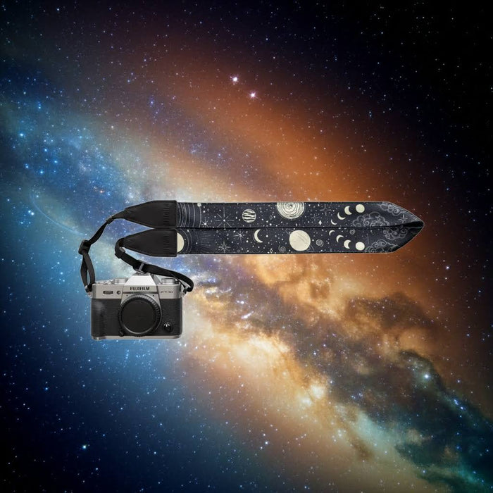 Wildtree Sun & Moon Camera Strap displayed on a vibrant stars and nebulae space backdrop, cosmic photography accessory.