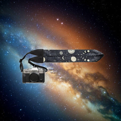 Wildtree Sun & Moon Camera Strap displayed on a vibrant stars and nebulae space backdrop, cosmic photography accessory.
