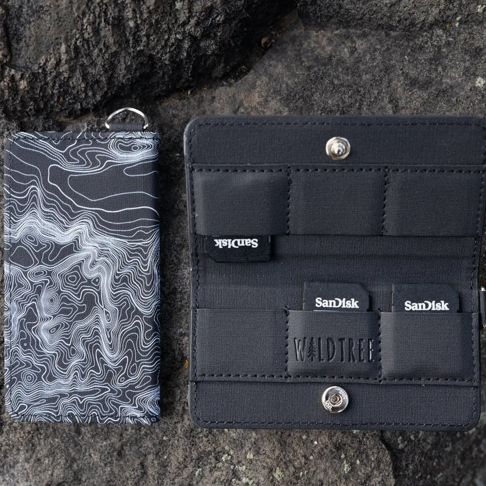 Wildtree Topographic Map SD/Switch card case next to branded pouch, perfect gaming accessory for storage and travel.