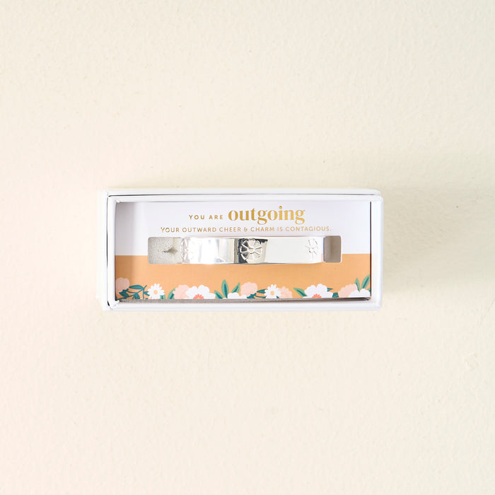 The Darling Effect’s You Are Outgoing Cuff Bracelet, featuring floral engravings, comes in a gift box that says “YOU ARE outgoing and YOUR OUTWARD CHEER & CHARM IS CONTAGIOUS”—a meaningful gift for someone special.